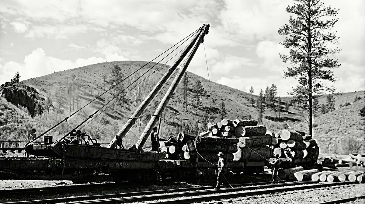 Digitally enhanced public domain photograph showing workers loading timber onto railcars using a crane during Arizona’s early railroad and logging expansion.
