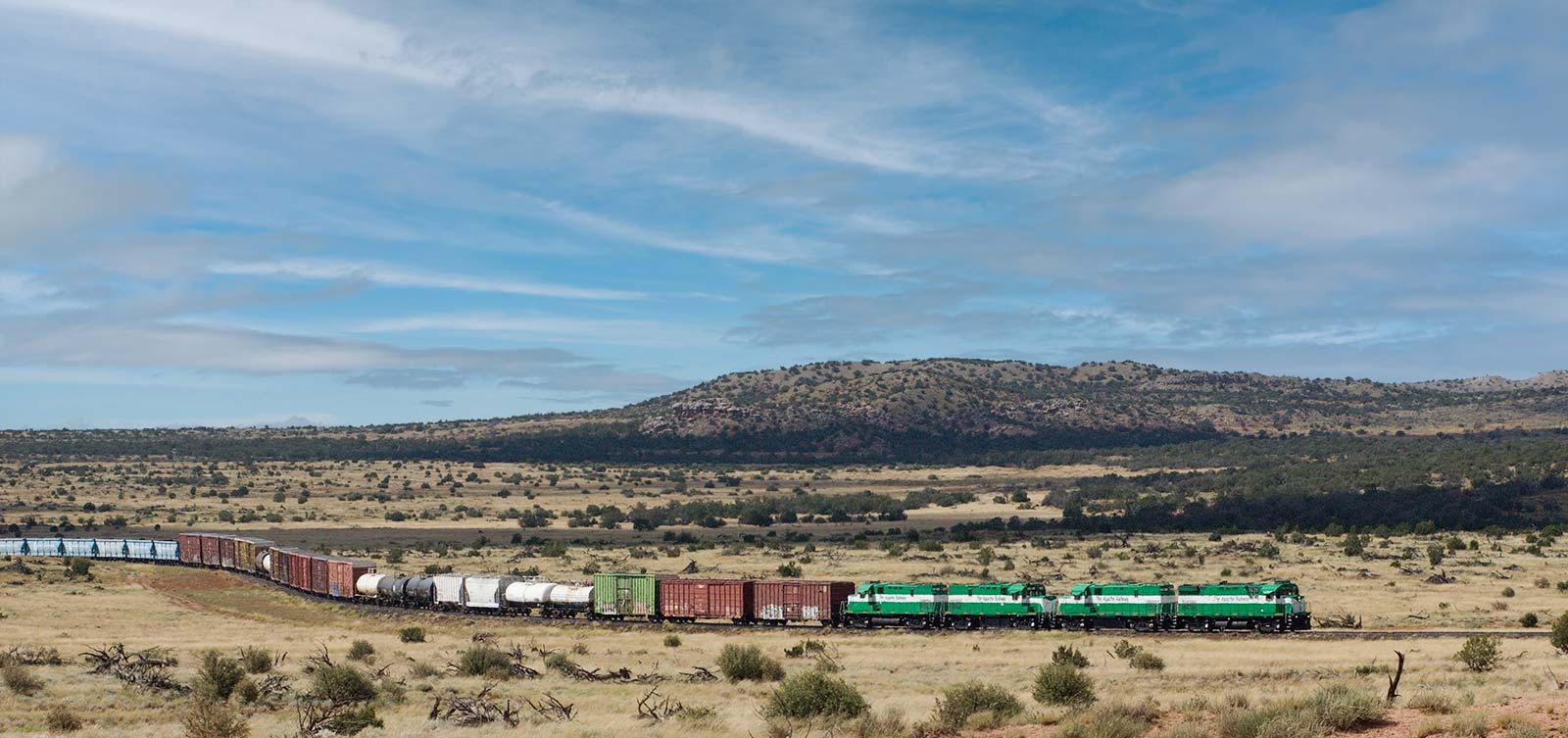 Apache Railway freight train moving across northeastern Arizona desert, illustrating short-line rail service connecting local shippers to the national rail network